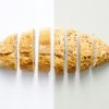 Freshly baked whole wheat bread sliced on a white background, showcasing its homemade texture.