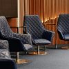 Elegant empty conference room with stylish blue leather chairs and wooden paneling.